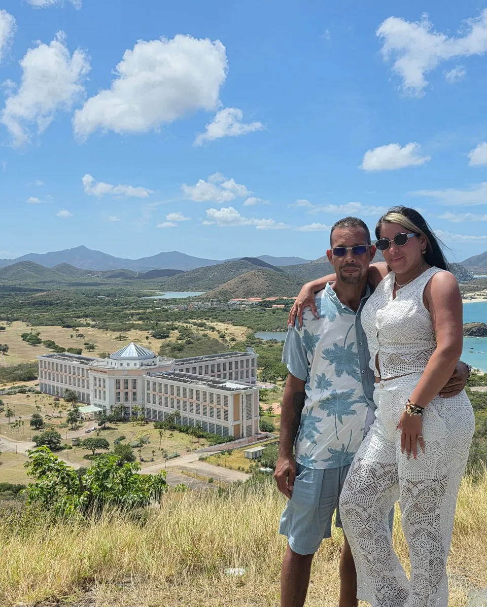 Pareja en mirador con vista a la Universidad de Margarita, montañas, lagunas y costa en la isla.